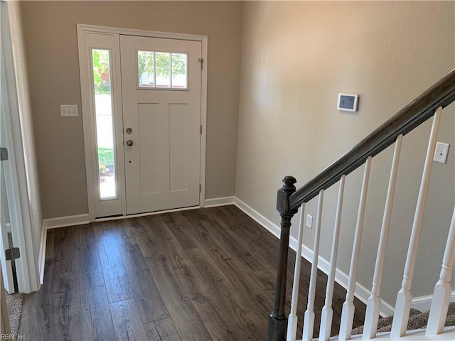 entrance foyer featuring dark wood finished floors, stairs, and baseboards