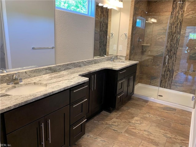 bathroom with a tile shower and vanity