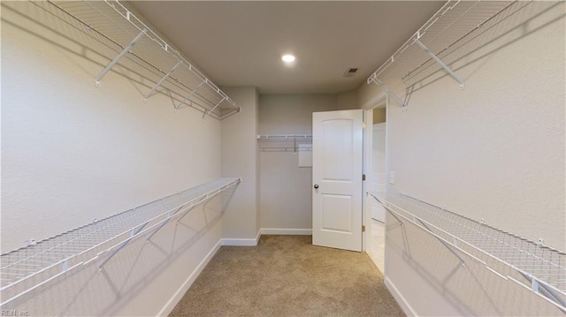 spacious closet featuring visible vents and light carpet