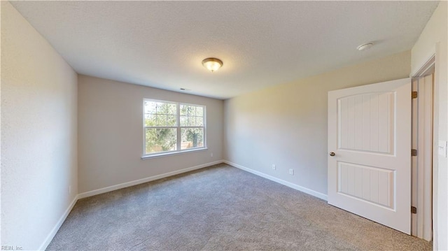 unfurnished room with a textured ceiling, baseboards, and carpet floors