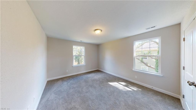 unfurnished room with visible vents, carpet flooring, and baseboards