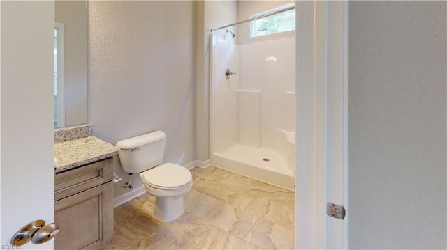 bathroom with a shower, baseboards, toilet, and vanity