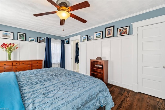 bedroom with crown molding, a decorative wall, and dark wood-style flooring