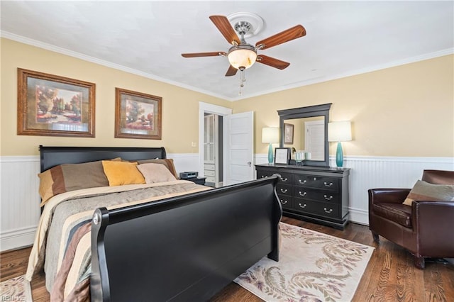 bedroom with crown molding, wood finished floors, and wainscoting