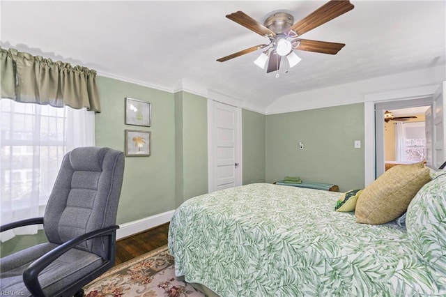 bedroom featuring baseboards, wood finished floors, a ceiling fan, and vaulted ceiling