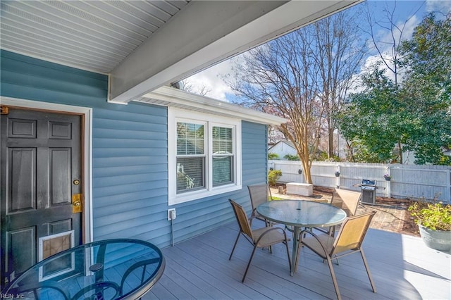 deck with area for grilling, outdoor dining space, and fence