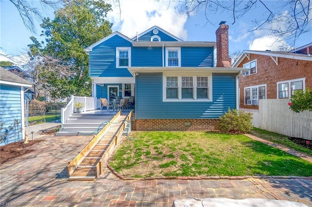 rear view of property with stairway, fence, a lawn, and a chimney