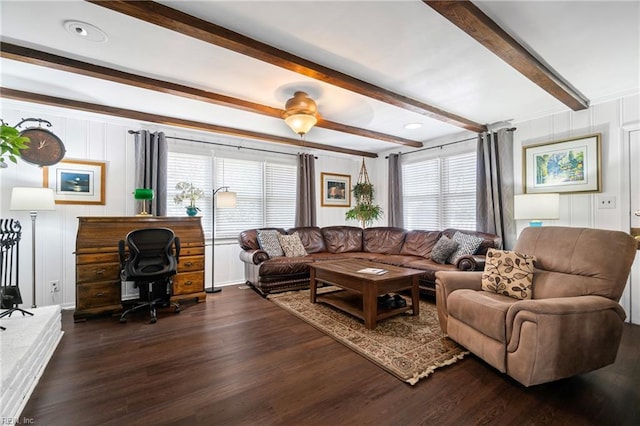 living area with beam ceiling, a decorative wall, and dark wood-style floors