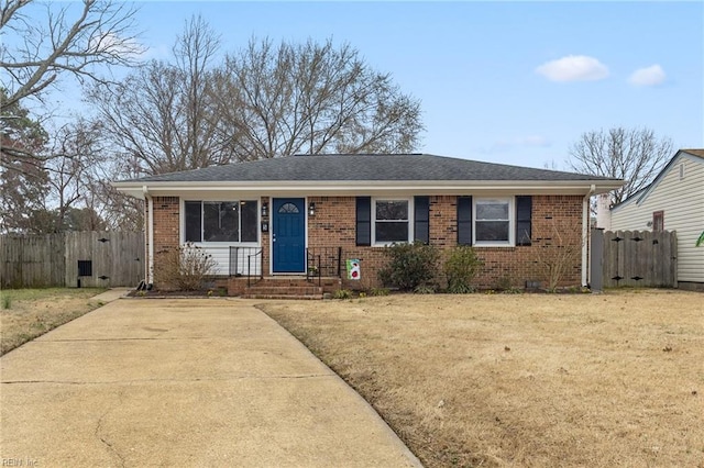 ranch-style home featuring brick siding, a front lawn, and fence