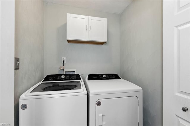 washroom featuring cabinet space and washer and dryer