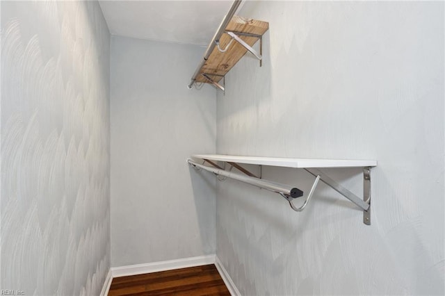 walk in closet with wood finished floors