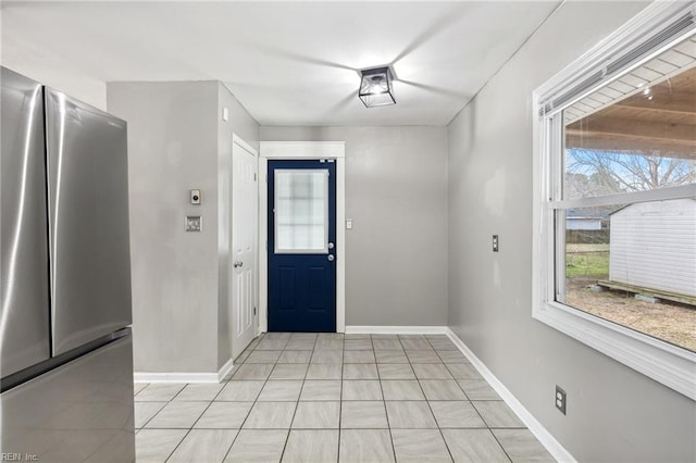 foyer entrance featuring light tile patterned floors and baseboards