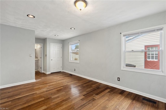 empty room featuring visible vents, recessed lighting, baseboards, and wood finished floors