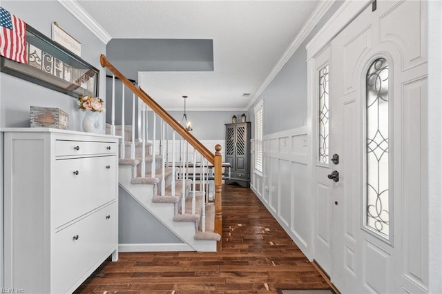 entryway with stairs, plenty of natural light, dark wood-style floors, and ornamental molding