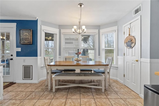 dining area featuring a chandelier, visible vents, wainscoting, and light tile patterned floors