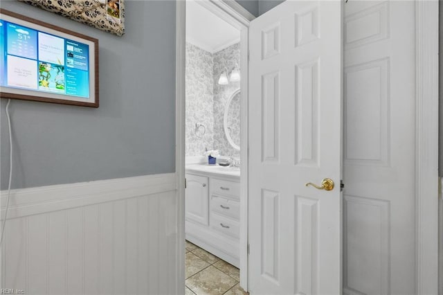 bathroom featuring tile patterned floors, vanity, and wainscoting