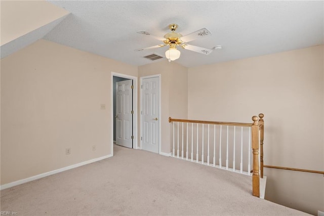 spare room featuring baseboards, a textured ceiling, ceiling fan, and carpet flooring