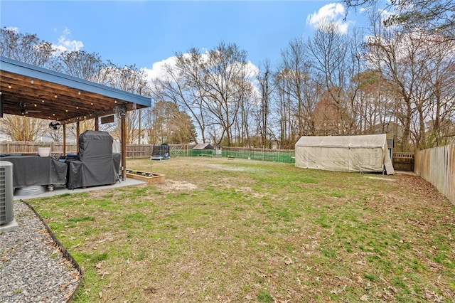 view of yard featuring an outbuilding, a storage unit, and a fenced backyard