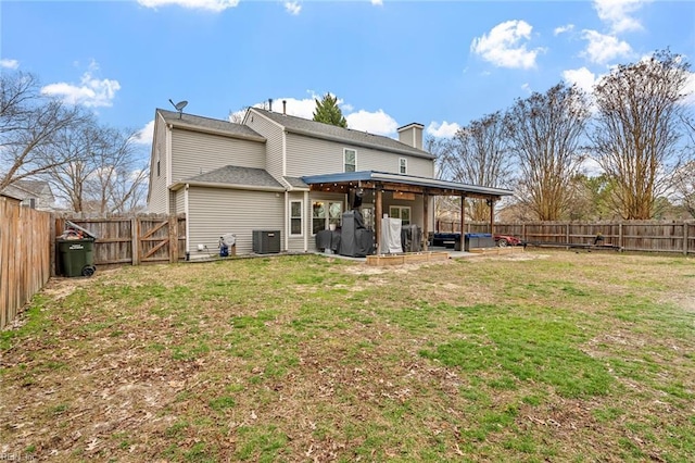 back of property featuring a patio, a lawn, central AC, and a fenced backyard