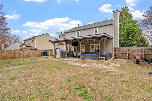 back of house with a patio, a fenced backyard, a yard, an outdoor hangout area, and a chimney