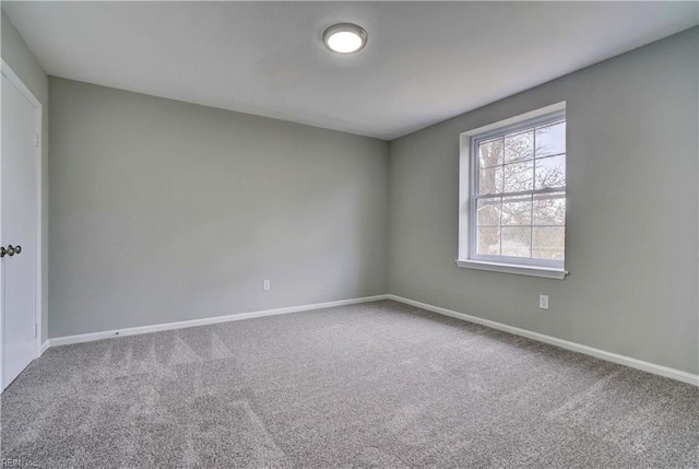 spare room with baseboards and carpet