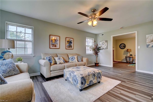 living room featuring baseboards, ceiling fan, and wood finished floors