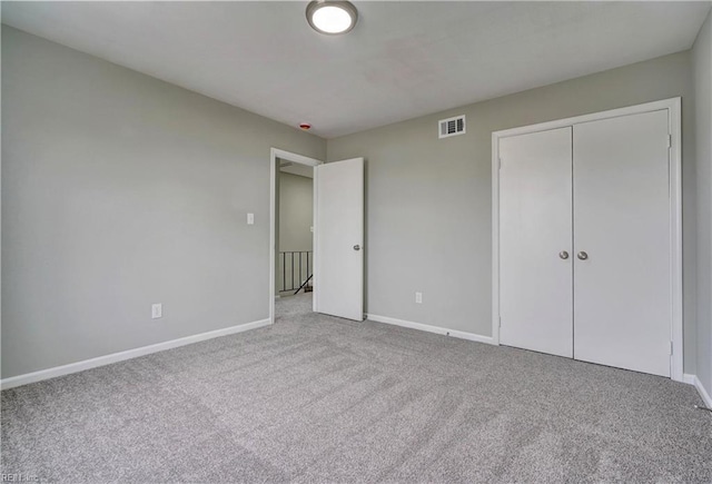 unfurnished bedroom featuring visible vents, baseboards, a closet, and carpet flooring