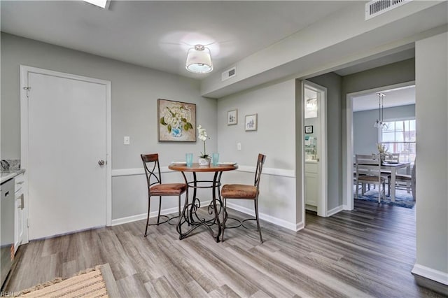 dining room with visible vents, baseboards, and wood finished floors