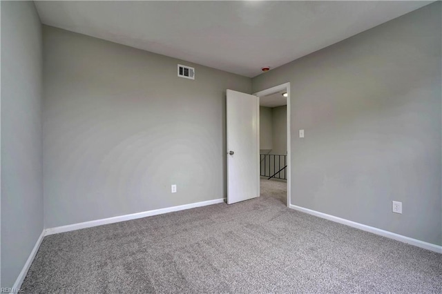 unfurnished room with visible vents, baseboards, and carpet