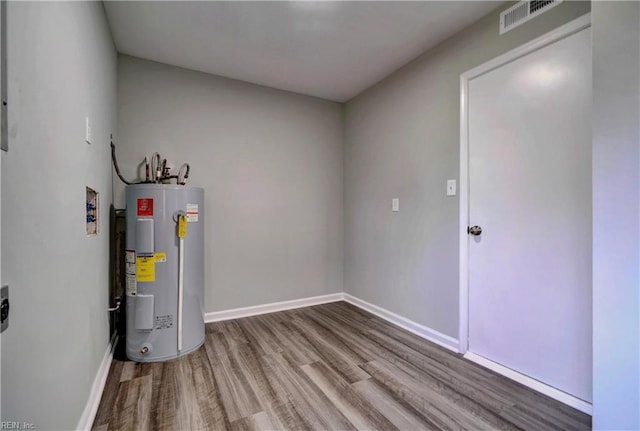 utility room with visible vents and water heater