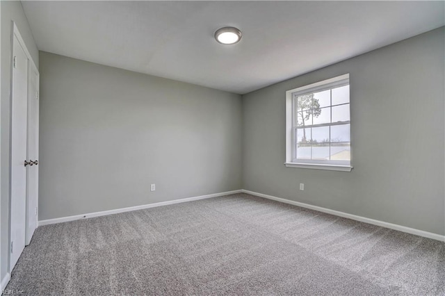 carpeted spare room featuring baseboards