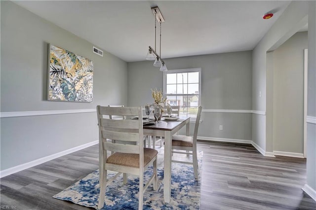 dining room featuring visible vents, baseboards, and wood finished floors