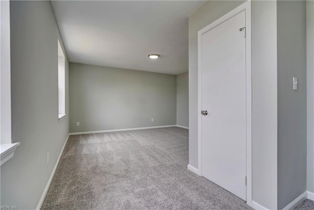 empty room featuring baseboards and carpet floors