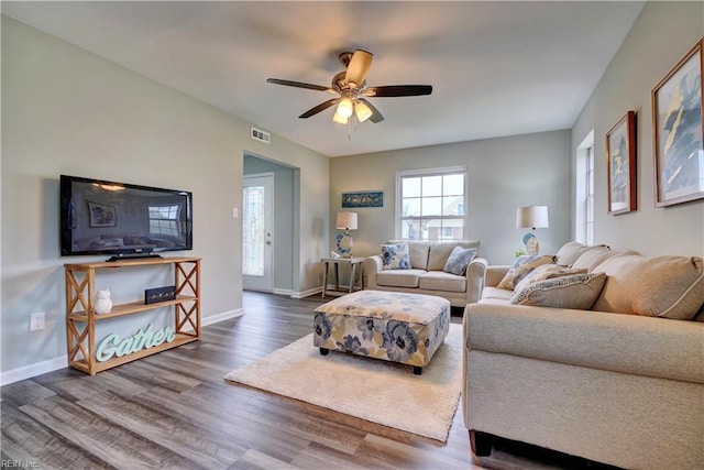 living room featuring visible vents, wood finished floors, baseboards, and ceiling fan