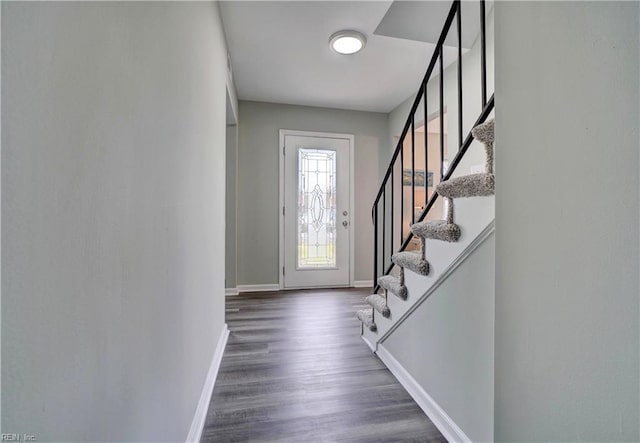 foyer entrance with stairs, baseboards, and dark wood-style flooring