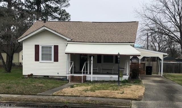 view of front of home featuring driveway, fence, covered porch, a shingled roof, and a carport