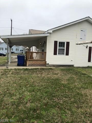 exterior space with an attached carport and a front lawn