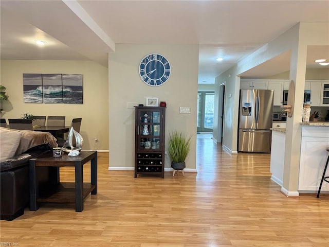 living area with light wood-style flooring and baseboards