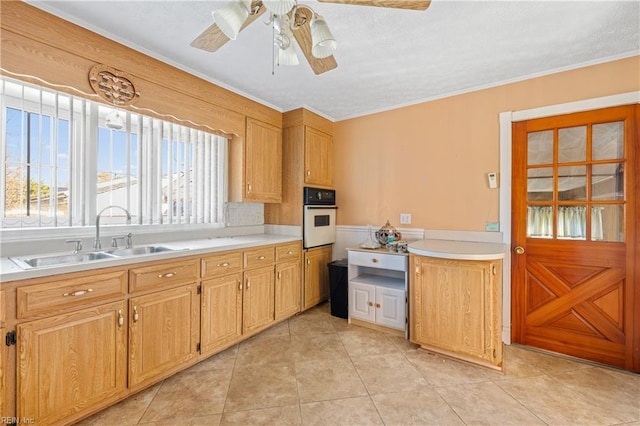 kitchen with ceiling fan, light countertops, light tile patterned floors, white oven, and a sink