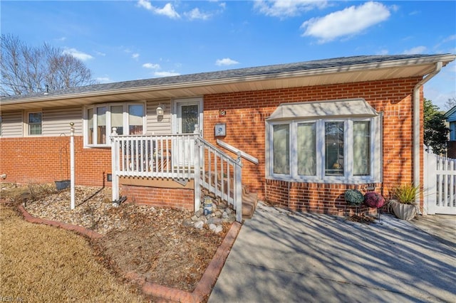 view of front of home featuring fence and brick siding