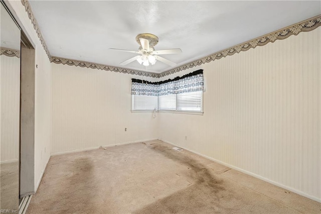 carpeted spare room featuring ceiling fan