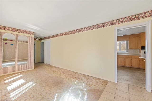 empty room with light tile patterned flooring and baseboards