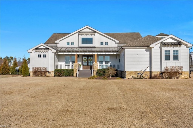 view of front of house with a standing seam roof, a porch, board and batten siding, a shingled roof, and metal roof