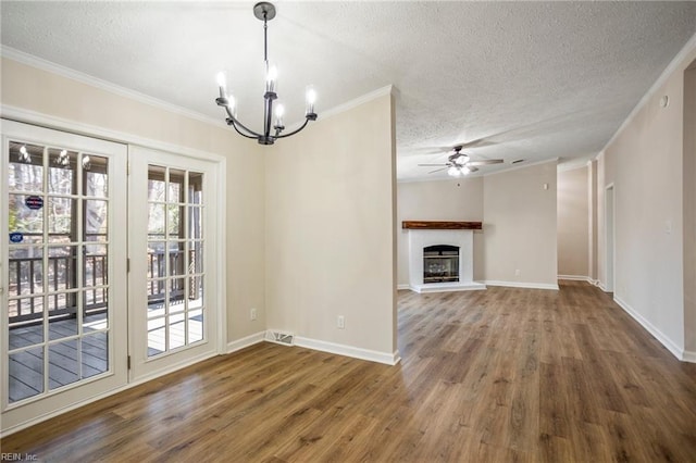 unfurnished dining area featuring visible vents, ceiling fan with notable chandelier, ornamental molding, and wood finished floors