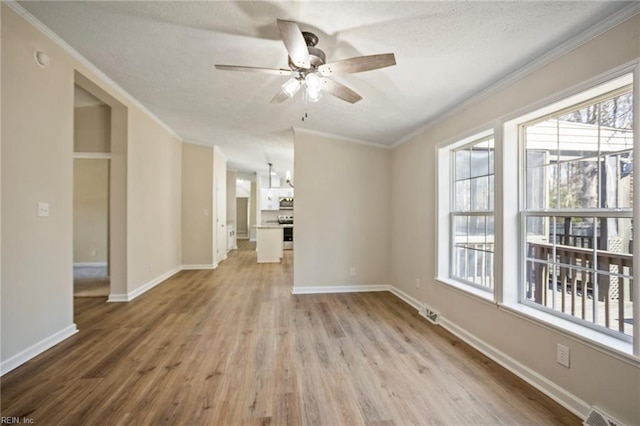 unfurnished living room featuring crown molding, baseboards, light wood-style flooring, a textured ceiling, and a ceiling fan