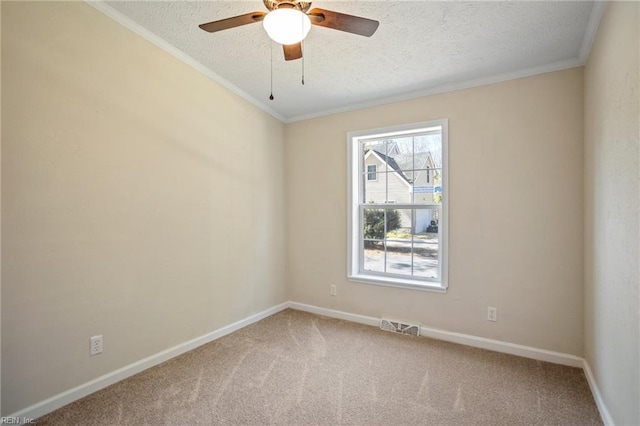 empty room featuring visible vents, carpet, ornamental molding, a textured ceiling, and a ceiling fan