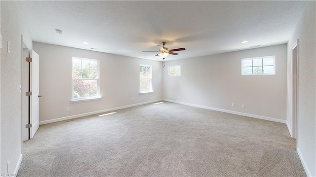 carpeted spare room with a textured ceiling, plenty of natural light, baseboards, and ceiling fan