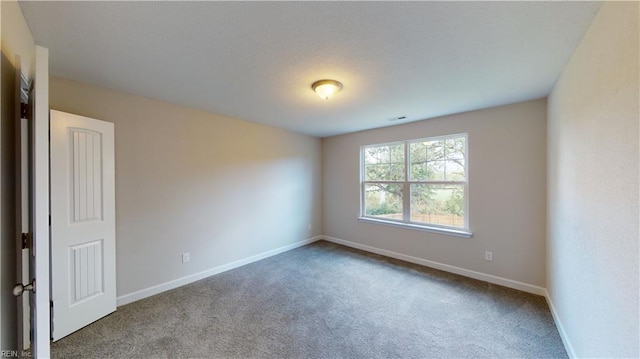 carpeted spare room featuring visible vents and baseboards