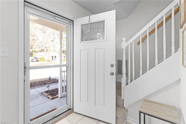 entryway with stairway and light tile patterned flooring