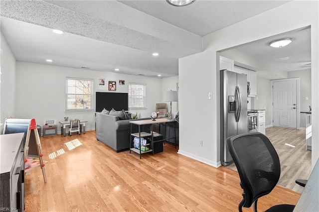 office space featuring recessed lighting, baseboards, a textured ceiling, and light wood finished floors